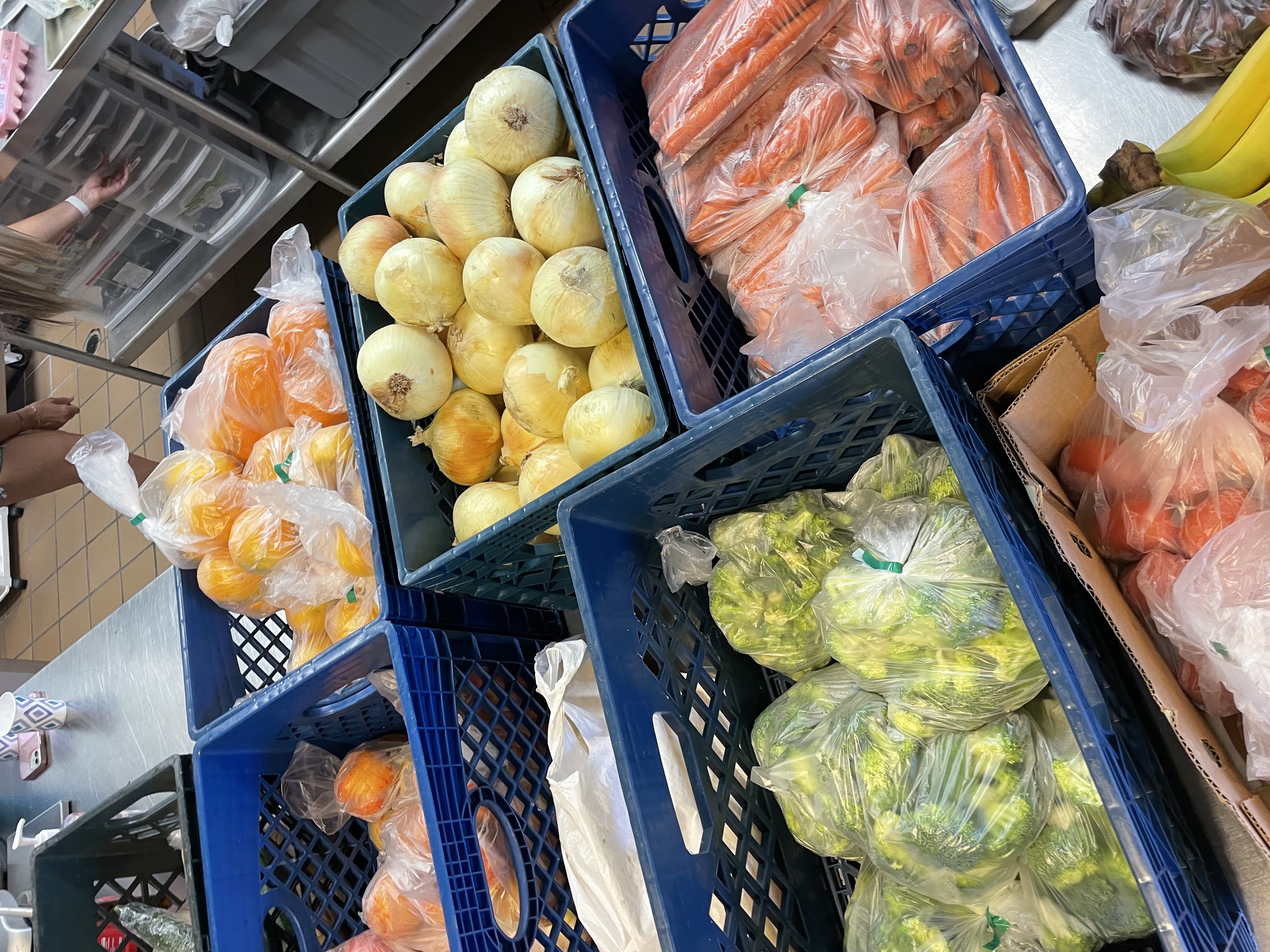 Crates of onions, carrots and broccoli ready for the kitchen